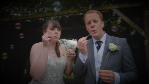 Couple blowing bubbles at their south west wedding venue