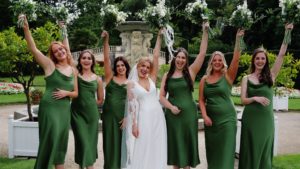 A bridal party cheering with their bouquets in the air at Mount Edgcumbe captured by south west wedding videographer