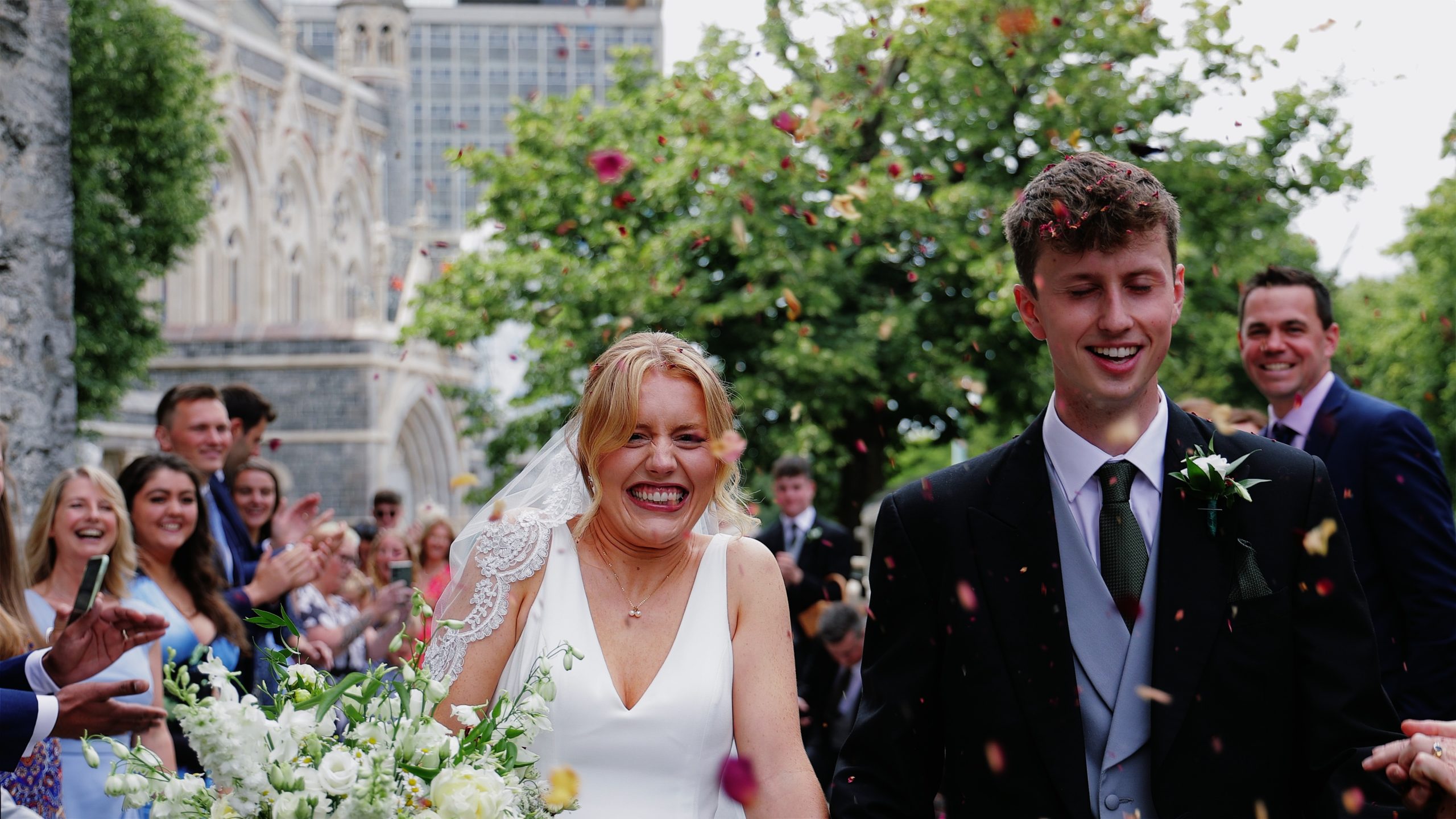 wedding-videography Confetti exit at St Andrew’s Church in Plymouth with bride and groom walking out of the church surrounded by guests