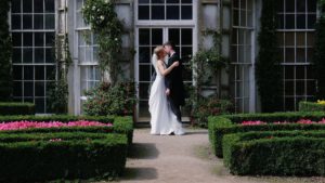 A bride and groom share a kiss in front of a gardenhouse at Mount Edgcumbe a south west wedding venue