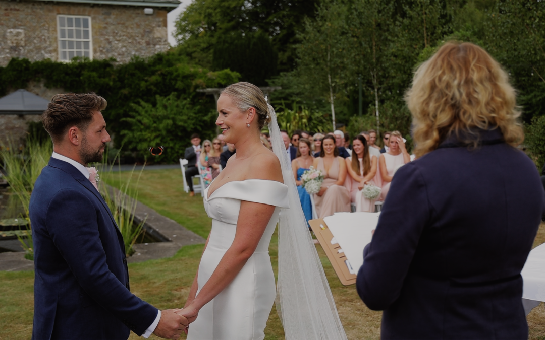 Candid wedding ceremony moment at Glebe Wedding Barn with a butterfly flying between bride and groom as they hold hands