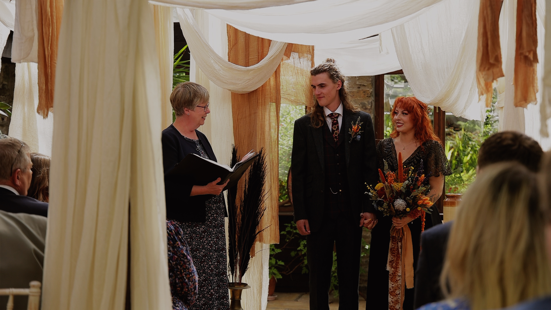 A bride and groom standing at the top of the aisle at Westcott Barton