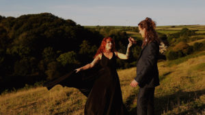 Couple hand in hand outdoors as wedding videographer and photographer work together to capture their day