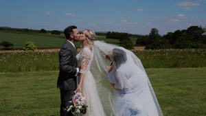 Couple kissing down aisle at their outdoor wedding ceremony