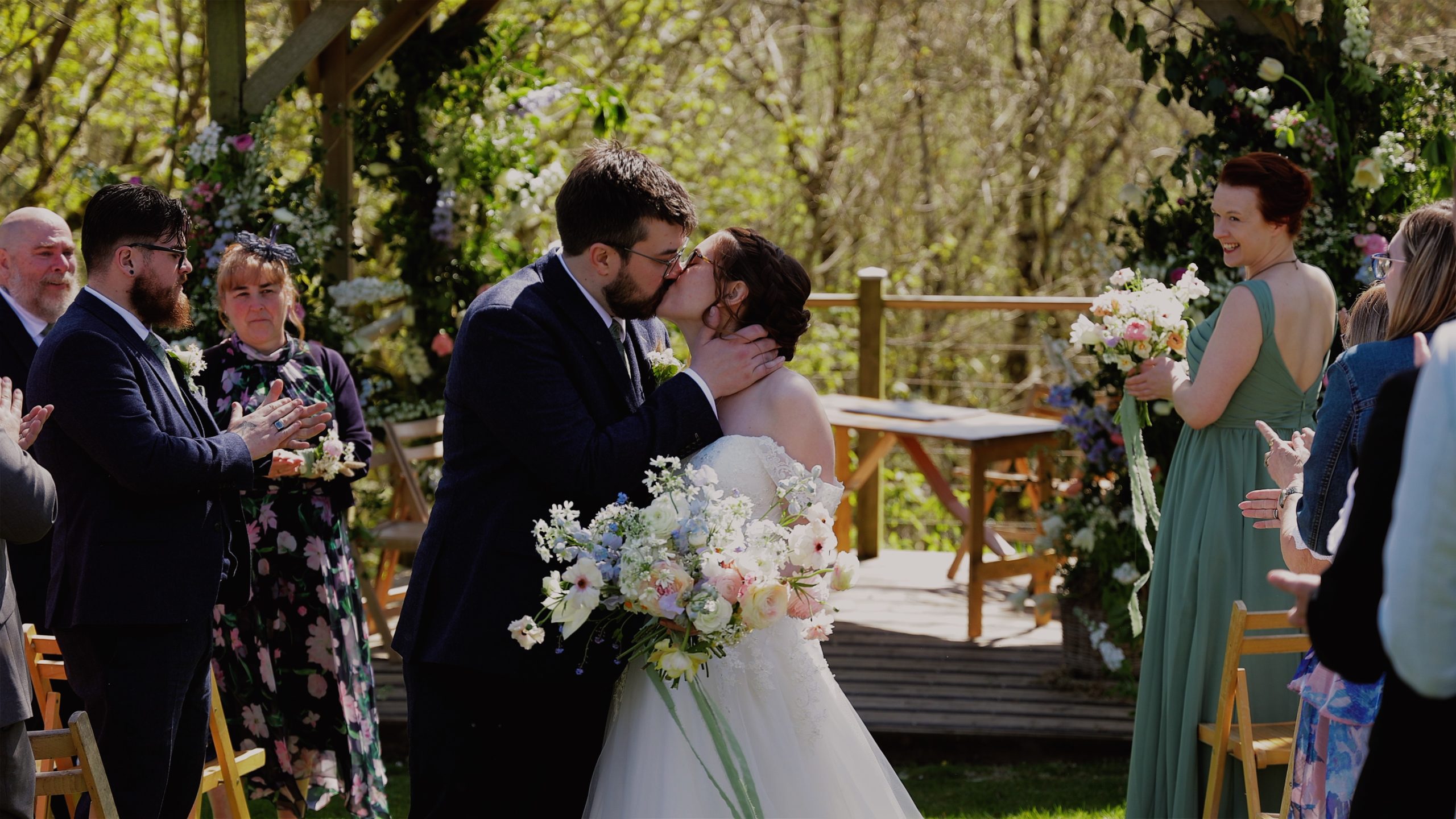 A newly-wed couple share a kiss as they walk down the aisle after their wedding ceremony at The Green