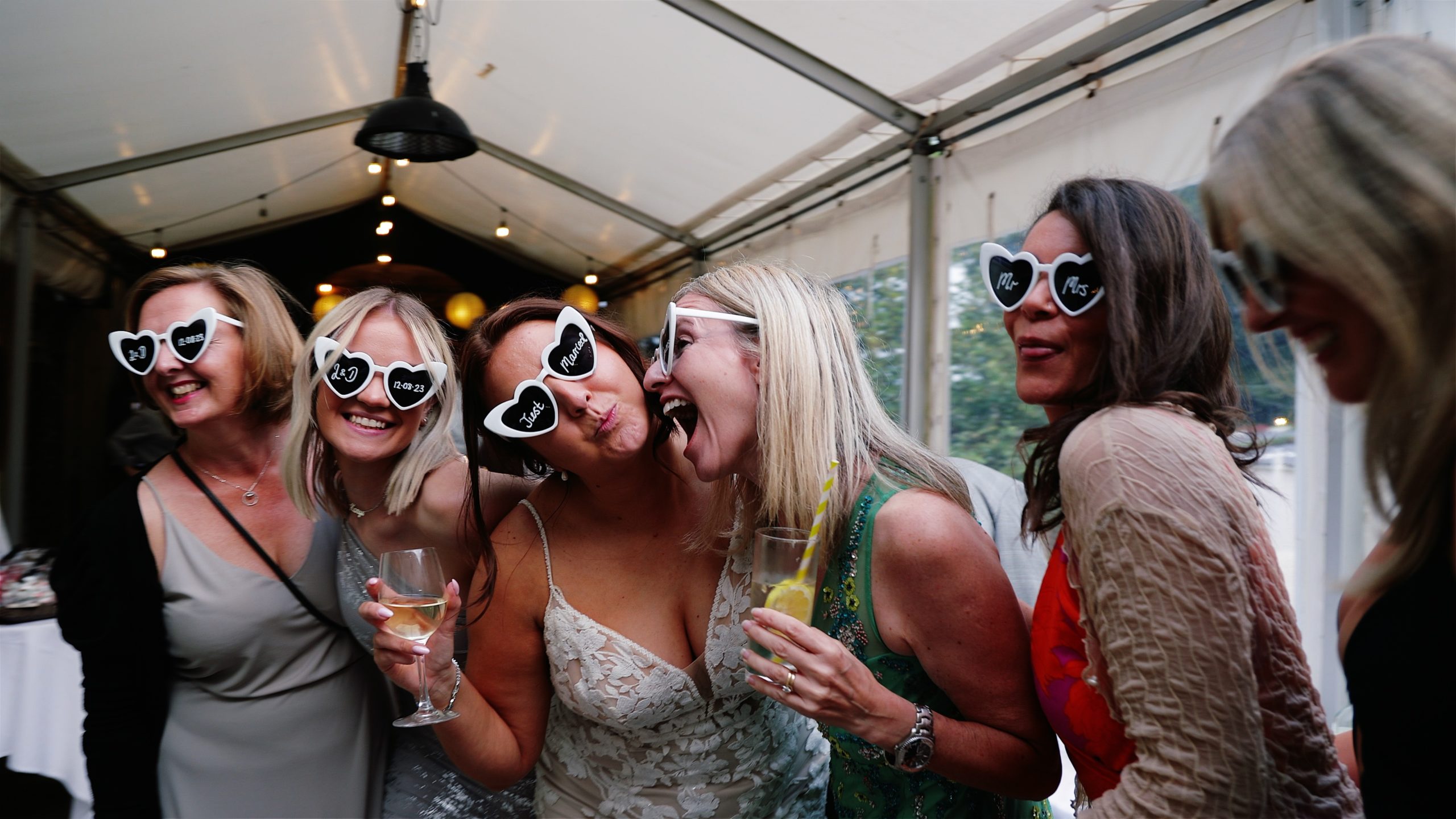 A bride and her friends striking a fun pose with heart shaped sun glasses at Trenderway Farm