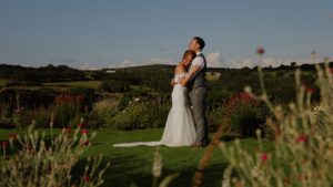 Couple standing hugging at their outdoor wedding ceremony