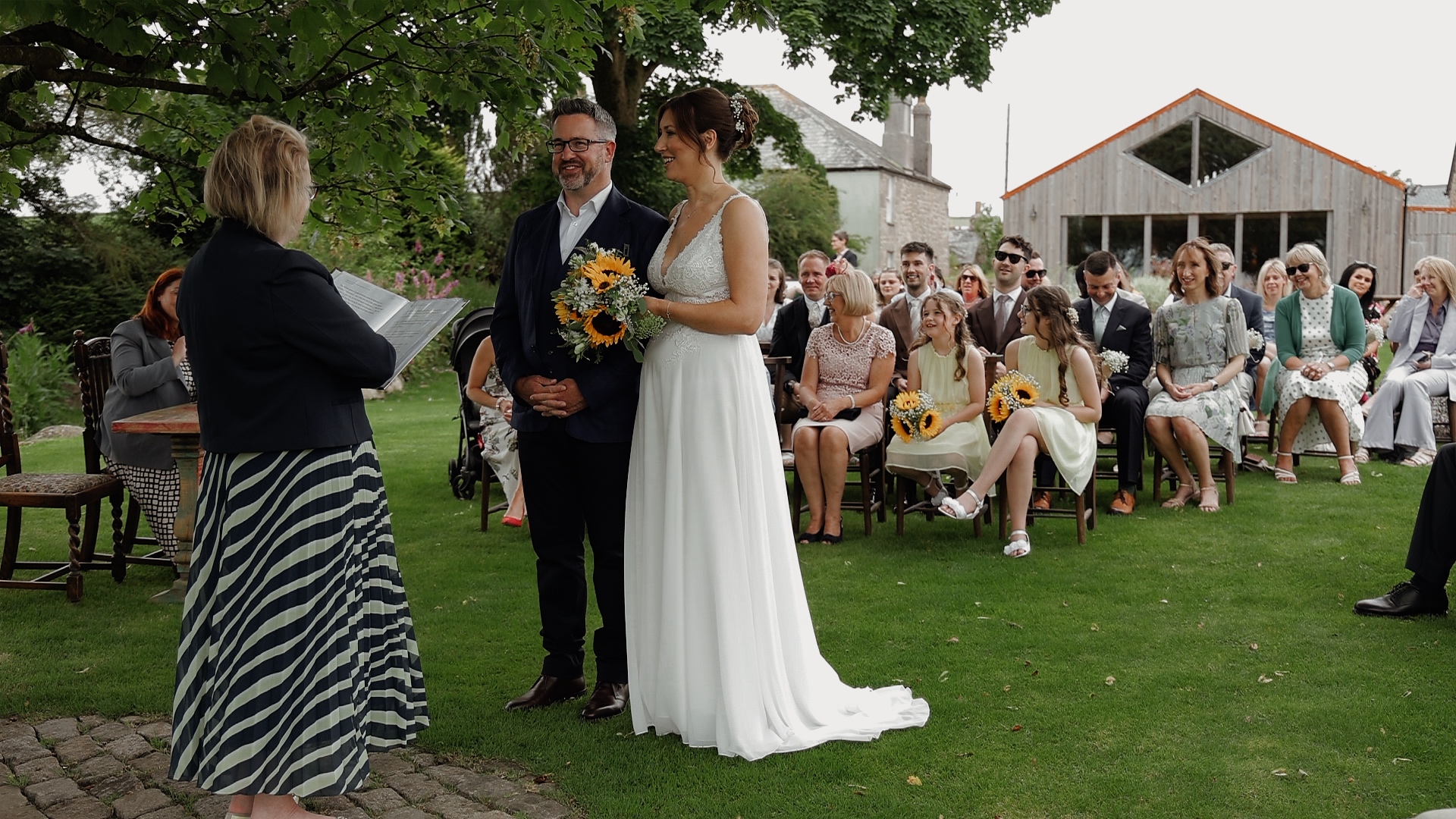 A bride and groom standing in front of the registrar during their wedding ceremony outside at Avalen Farm