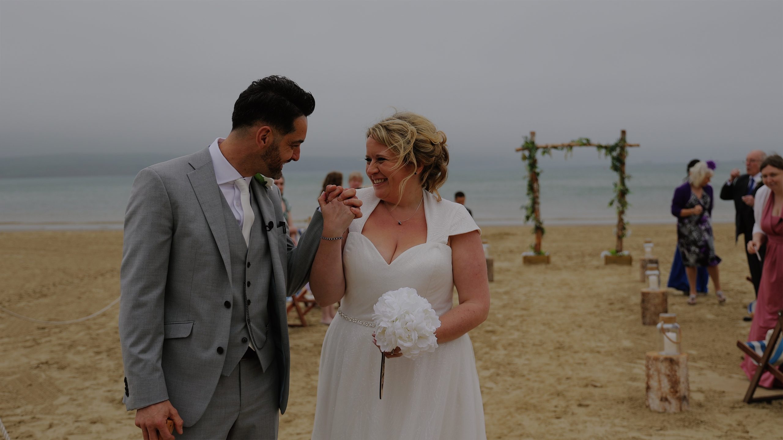 Bride and groom celebrating their wedding ceremony on Weymouth beach