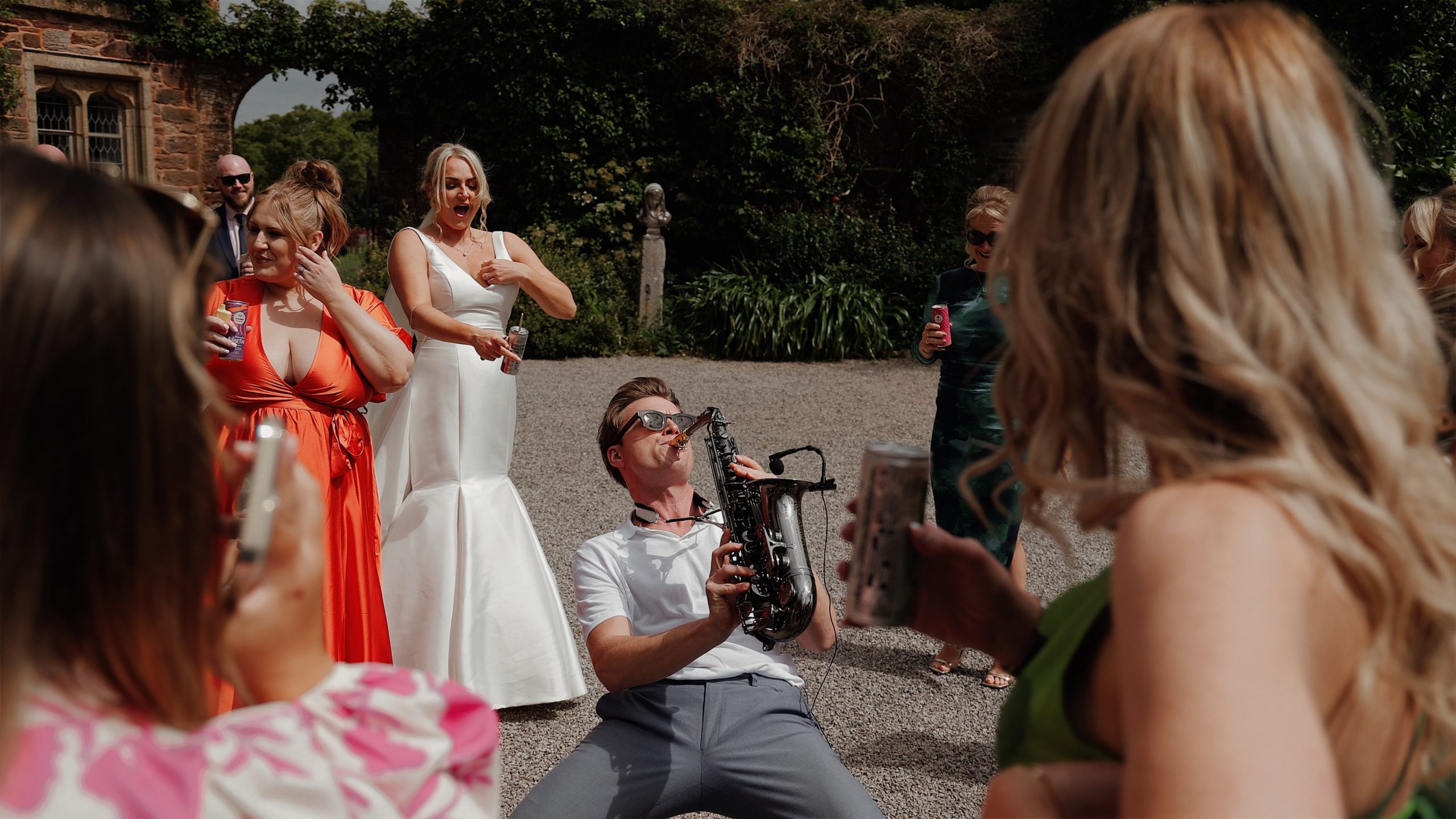 A saxophone player playing live music for wedding guests at Mount Edgcumbe House