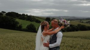 Couple arm in arm outdoors as wedding videographer and photographer work together to capture their day