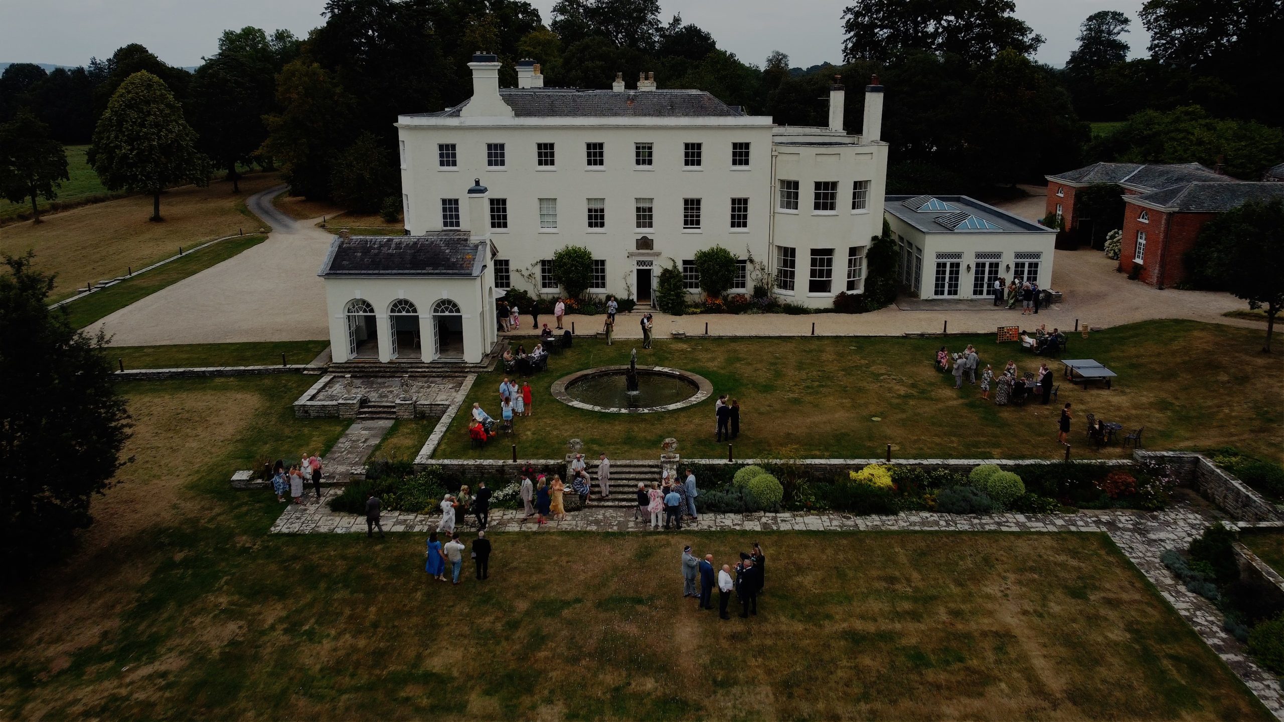 A drone shot of Rockbeare Manor with guests mingling outside
