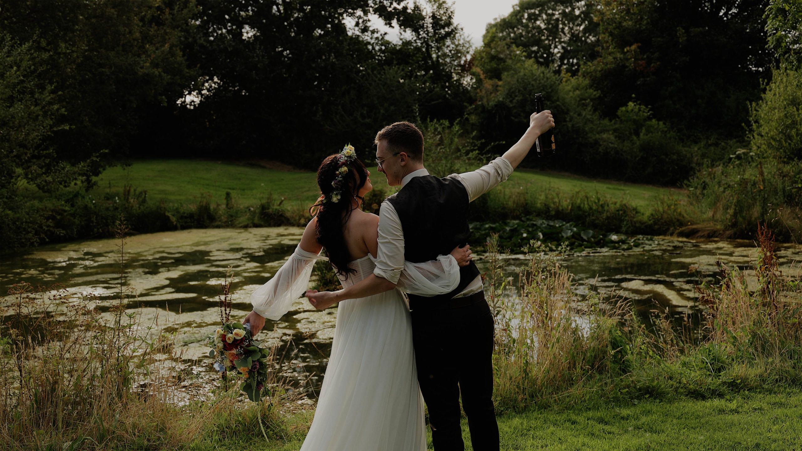 Beth & Calum - Hareston manor pond hug A bride and her friends striking a fun pose with heart shaped sun glasses at Trenderway Farm