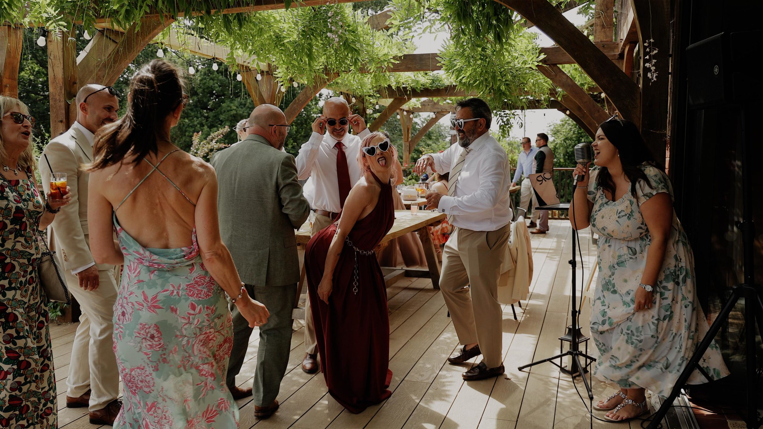 A bride and groom standing with arms around each others backs as they watch fireworks at St Audries Park